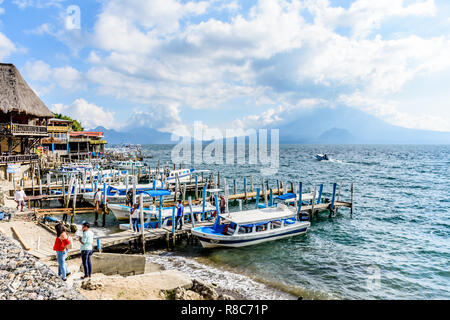 Panajachel, Lac Atitlan, Guatemala - 12 novembre 2018 : restaurants au bord du lac, les jetées et les bateaux avec des volcans Toliman et volcan Atitlan derrière. Banque D'Images