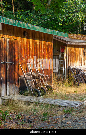 Outils s'appuyant sur un mur en bois d'un vieux hangar Banque D'Images