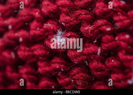 Libre d'un plaid en tricot rouge avec quelques flocons sur elle. La prise de vue macro. Banque D'Images