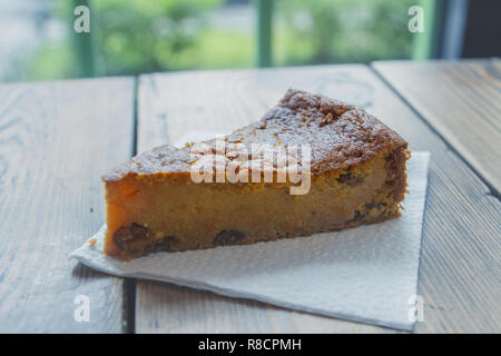 Délicieuse tarte aux pommes charlotte sur une serviette blanche sur une table dans un café par la fenêtre. Close up side view Banque D'Images