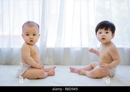 Deux petits bébés mignons photo. Couches bébé portant en chambre blanche. 187 Banque D'Images