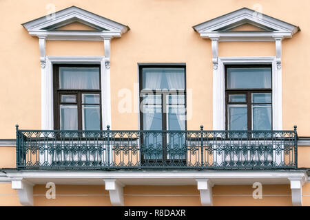 Deux fenêtres et une porte contre un mur beige avec un balcon. À partir d'une série de Saint-Pétersbourg. Banque D'Images