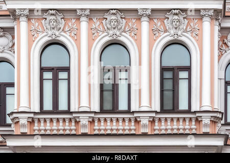 Trois fenêtres cintrées contre un mur de couleur rose avec un bas-relief et de colonnes. À partir de la fenêtre Série de Saint-Pétersbourg. Banque D'Images