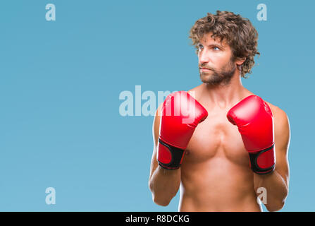 Handsome young man wearing boxing gloves boxer sur fond isolé smiling à côté et regardant loin de penser. Banque D'Images