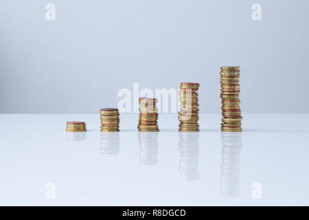 Des piles de pièces d'euros dans l'ordre croissant sur la table et l'arrière-plan gris clair. Simple et minimaliste. Concept photo de la croissance financière. Banque D'Images