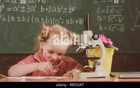 Petite fille en classe l'étude de la chimie à l'école. Le travail d'écolière sur la recherche en chimie avec microscope, filtre vintage Banque D'Images