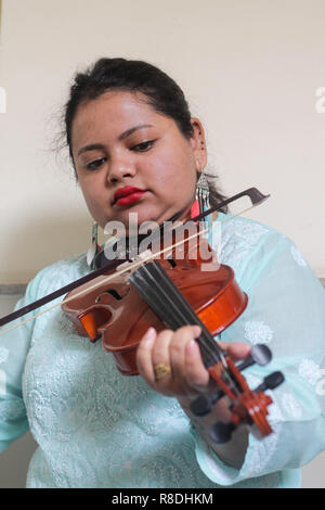 Une belle jeune femme jouant de l'instrument de musique en bois du violon. Banque D'Images