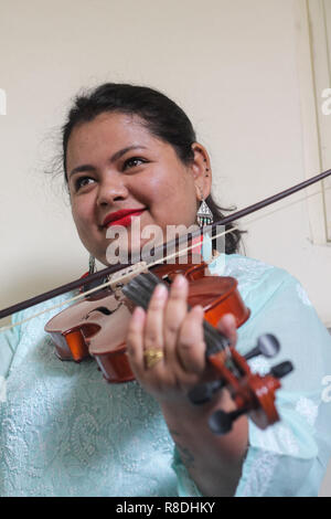 Une belle jeune femme jouant de l'instrument de musique en bois du violon. Banque D'Images