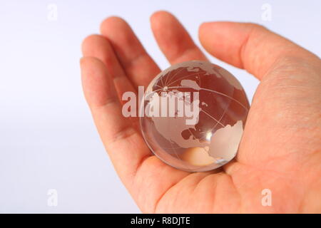 Photo image concept de puissance mondiale, l'Organisation mondiale de tenir en main, le pouvoir de contrôler le monde, globe en verre à Palm