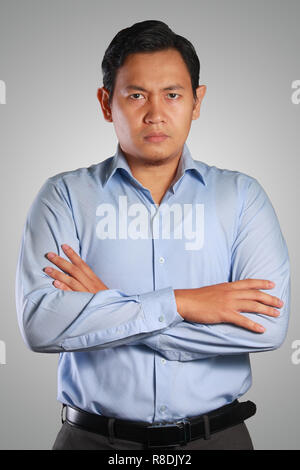 Photo image portrait d'un jeune homme d'Asie à la colère avec à l'avant avec les bras croisés devant sa poitrine Banque D'Images
