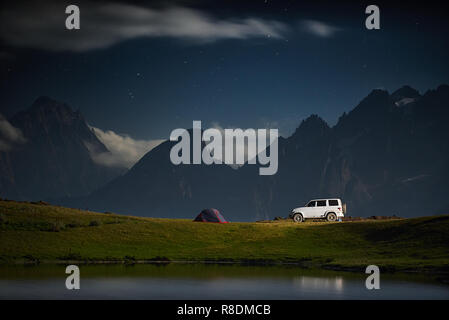 Camping avec une voiture, tente de nuit avec des montagnes au clair de lune Banque D'Images