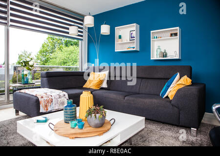 Salon moderne avec un canapé design et de couleurs jaune et bleu. Banque D'Images