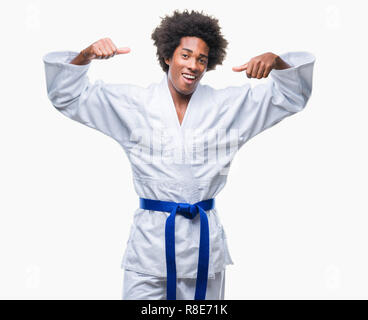 South American man wearing kimono karaté sur fond isolés montrant les muscles des bras fier sourire. Concept de remise en forme. Banque D'Images