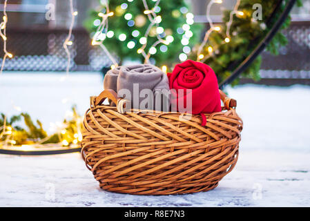 Panier en osier avec des couvertures chaudes sur la neige à l'extérieur Banque D'Images