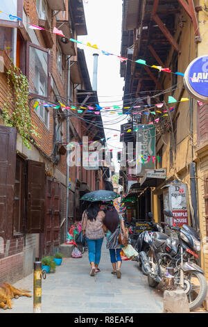 Mère et fille tenant un parapluie et descendre dans la rue Patan, Lalitpur, au Népal. Banque D'Images