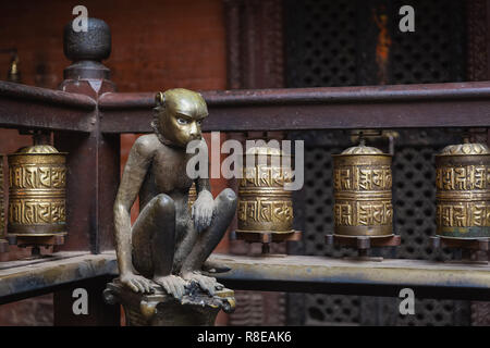 Golden monkey et roues de prière à Hiranya Varna Mahavihar, le Temple d'or dans la ville historique de Patan, également connu sous le nom de Lalitpur, au Népal. Banque D'Images