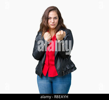 Taille plus belle jeune femme portant une veste en cuir de mode sur fond isolé prêt à combattre avec fist, geste de défense en colère et contrarié fa Banque D'Images