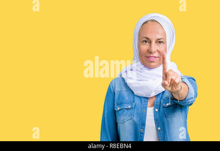 L'âge moyen est de l'arabe arabe femme portant le hijab sur fond isolé avec le doigt pointant vers le haut et l'expression de colère Banque D'Images