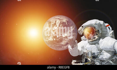 Asteronaut dans l'espace et le bleu de la planète Terre et le soleil. éléments de cette image fournie par la NASA Banque D'Images