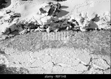 Les eaux sauvages de la rivière Skjalfandafljot circulant dans la cascade de Godafoss. Vue aérienne, semi-rivière gelée, résumé , fond noir et blanc Banque D'Images