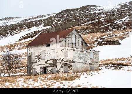 Vieux bâtiment abandonné se dresse dans un paysage couvert de neige, Fjords de l'Ouest, région de l'Islande. Banque D'Images