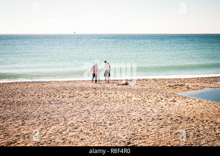 Deux pêcheurs avec des cannes à pêche sur le bord de la mer. Vue arrière. Jour d'été ensoleillé. Place pour le texte. Banque D'Images