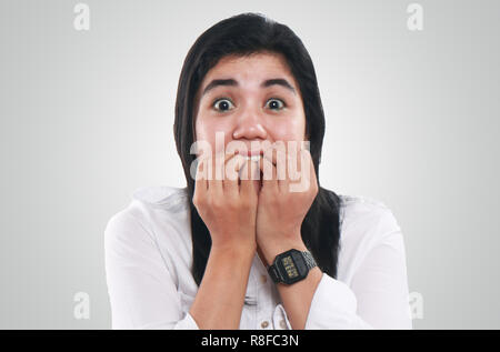 Photo image portrait d'une jeune belle femme asiatique l'air très nerveux et inquiet, avec de grands yeux sur son visage tandis que mordre ses ongles Banque D'Images