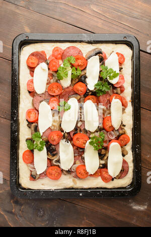 Vue de dessus des pizzas sur une plaque sur fond de bois brun Banque D'Images