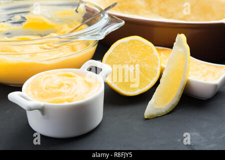 Le lait caillé de citron dans des bocaux avec tranche de citron sur fond gris Banque D'Images