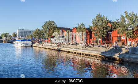 OULU, FINLANDE - le 21 juillet 2016 : des gens assis le long du port, dans le centre d'Oulu en Finlande jouissant d'un panorama exceptionnel ensoleillé et chaud le soir. Banque D'Images