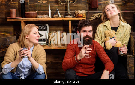 Les amis de s'amuser, parler et boire des boissons chaudes dans un intérieur en bois. Les amis passent et voyages à l'intérieur confortable. Concept de communication. Homme et femmes sur visages heureux de discuter et de boire du vin. Banque D'Images
