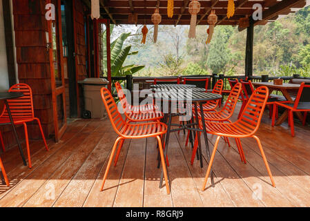 Table et chaises extérieur orange dans café bistro dans journée de détente, voyage, saison, temps, vacances, gastronomie, concept Banque D'Images