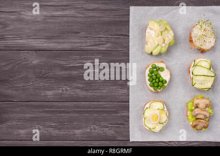 De savoureux sandwiches végétariens préparés avec des oeufs de caille,concombre, champignons, l'avocat, les amandes, les verts et les petits pois. micro Image avec copie espace, horizon Banque D'Images