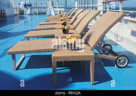 Des chaises longues et des tables dans la zone lounge sur le pont d'un paquebot de croisière Banque D'Images