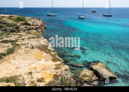 Des eaux cristallines et voiliers du Cala Azzurra, l'une des plages les plus populaires de Favignana, Îles Égades, Sicile, Italie Banque D'Images