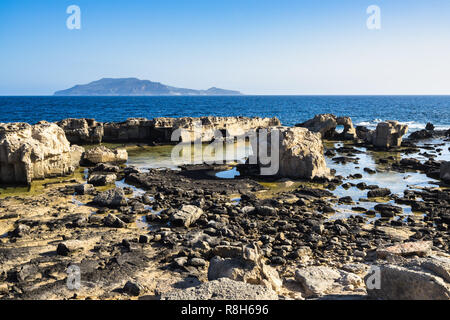 Scenic côte rocheuse de Favignana dans une journée ensoleillée de l'île de Levanzo en arrière-plan, les îles Égades, Sicile, Italie Banque D'Images