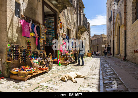 Scène de rue typique à Erice avec un couchage chien en face d'une boutique de souvenirs touristiques. La province de Trapani, Erice, Sicile, Italie, avril 2018 Banque D'Images