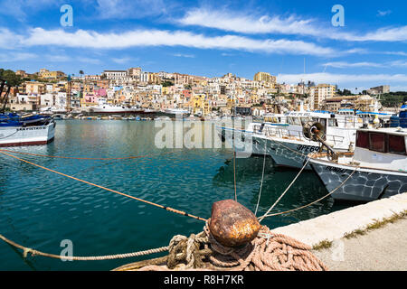 Bollard amarrage à Sciacca port. Bateaux de pêche sur le droit et les bâtiments de la vieille ville pittoresque sur l'arrière-plan. Sciacca, Sicile, Italie Banque D'Images