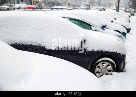 Les wagons couverts de neige. De nombreuses voitures en stationnement couvert de neige après les chutes de neige en hiver. Banque D'Images