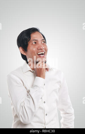 Photo image portrait d'un drôle de jeune homme d'Asie à heureux et souriant en pensant à quelque chose, portrait Banque D'Images