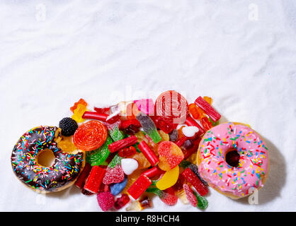 Bonbons bonbons colorés différents de sélection et le traite sur le sucre blanc métaphore de trop de sucre dans le régime alimentaire des enfants cause des problèmes de santé Nutrition Obe Banque D'Images