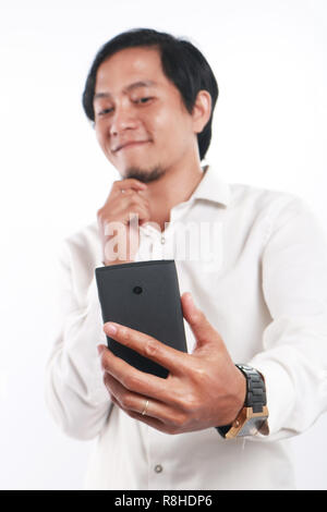 Photo image portrait d'un drôle de jeune homme d'Asie paraissait heureuse et souriant tout en prenant des photos de lui-même sur les selfies son smart phone, Close up por Banque D'Images
