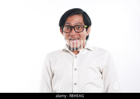 Photo image portrait d'un drôle de jeune homme asiatique avec des lunettes l'air très heureux, Close up portrait of smiling face avec, sur fond blanc Banque D'Images