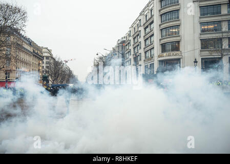 Paris, France. 15 décembre 2018. Des nuages de gaz lacrymogènes remplir la rue en face de la boutique Louis Vuitton. Gilet jaune (Gilet jaune) manifestation sur les Champs-Elysées, Paris, le 15 décembre 2018. Credit : Julien Garnier/Alamy Live News Banque D'Images