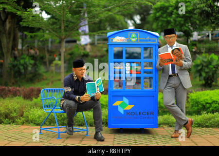 Gouverneur de Java Ouest Ridwan Kamil (à droite) avec le maire de Bogor Bima Arya (gauche) lire un livre lors du lancement de la Smart Case d'alphabétisation (Kolecer) service en Sempur Park. Kolecer, qui a été lancé par le Bureau régional Archives Bibliothèque (Dispusipda) de la province de Java ouest, sous la forme d'une mini-bibliothèque dans un espace public capable de charger 80 livres comme une forme d'innovation pour que les gens puissent occuper leur temps par la lecture. Banque D'Images