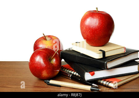 Cahiers, des stylos et des pommes sur une table isolated on white Banque D'Images