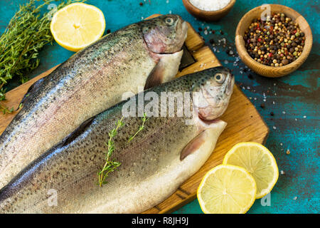 Le poisson frais. Saumon cru, citron et d'épices sur table ardoise bleue. Banque D'Images