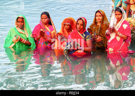 Groupe de femmes en saris colorés priant dans l'eau du Gange à Rishikesh, Inde Banque D'Images