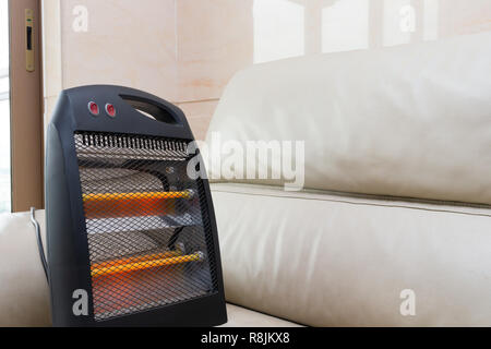 Radiateur électrique travaille sur un canapé Banque D'Images