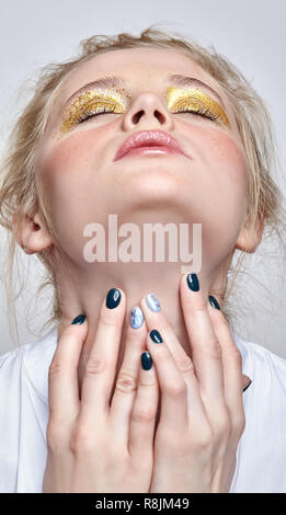 Visage de femme aux yeux clos et les mains près du cou. Femme avec des paillettes robe vogue beauté visage maquillage. Fille avec une peau parfaite et jaune fumé Banque D'Images